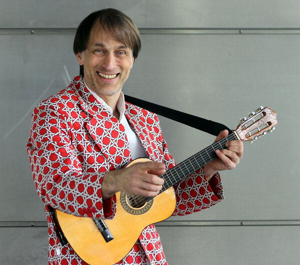 Thommi lachend mit Gitarre